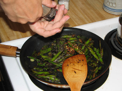 adding pepper to asparagus